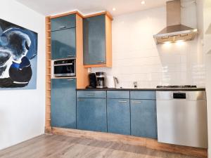 een keuken met blauwe kasten en een wastafel bij Vakantiewoning Goedgelegen MB01 in Middelburg