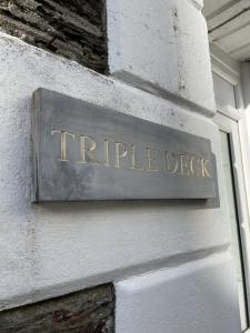 a sign on a building that reads triple deck at Triple Deck Cottage - 2mins from Mevagissey Harbour in Mevagissey