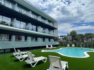 un hotel con sillas y una piscina en Hotel C31 en Castelldefels