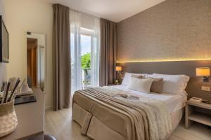 una camera d'albergo con un grande letto e una finestra di Hotel Renania a Bibione