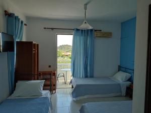 Pokój z 2 łóżkami i oknem w obiekcie Dolphin Apartments w mieście Faliraki