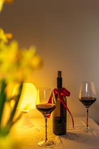 - une bouteille de vin et deux verres sur une table dans l'établissement Pensjonat OdNova, à Tylicz