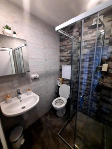 a bathroom with a toilet and a sink and a shower at Seaview Serenity Apartment in Burgas City
