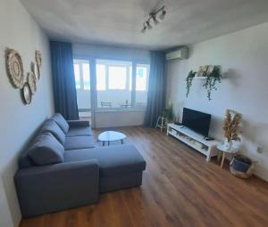 a living room with a couch and a tv at Seaview Serenity Apartment in Burgas City