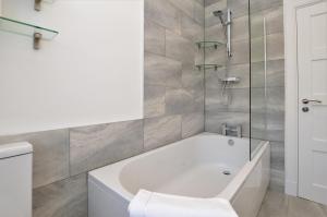 a bathroom with a white tub and a shower at Burnside in Tighnabruaich