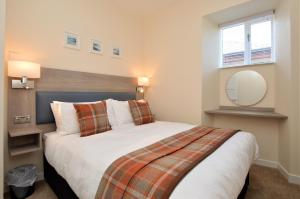 a bedroom with a large bed and a mirror at Burnside in Tighnabruaich