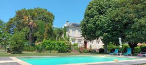 a swimming pool in front of a house at L'ESCALE DE BEL AIR Chambres d'hôtes in Gauriac