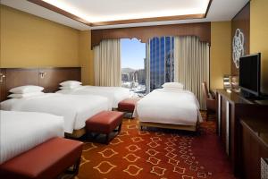 a hotel room with four beds and a flat screen tv at Jabal Omar Marriott Hotel Makkah in Makkah