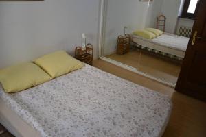 een slaapkamer met 2 bedden en een spiegel bij Casa tipica a Meride Al Punt da Gian in Meride