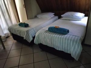 twee bedden naast elkaar in een kamer bij ADS Overnight Accommodation in Richards Bay