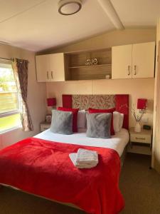 a bedroom with a large bed with a red blanket at Kielder in Morpeth