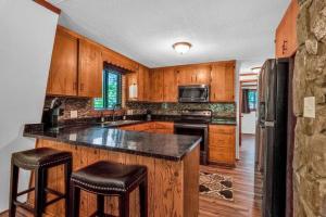 a kitchen with wooden cabinets and a black counter top at Sleeps 8! Fire Pit, Games, 15 Mins from Downtown Blue Ridge in Mineral Bluff