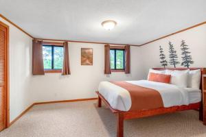 a bedroom with a large bed and windows at Sleeps 8! Fire Pit, Games, 15 Mins from Downtown Blue Ridge in Mineral Bluff