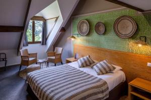 a hotel room with a bed and two plates on the wall at Garrigae Manoir de Beauvoir Poitiers Sud - Hotel & Spa in Mignaloux-Beauvoir