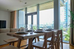 a dining room with a table with chairs and a large window at Mira Holiday Homes - Cozy apartment in Bluewaters in Dubai