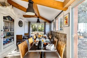 una sala da pranzo con tavolo e sedie di La Rose des Vents a Néoules