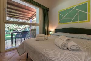 ein Schlafzimmer mit einem Bett und einem großen Fenster in der Unterkunft Residence Le Vele in Stintino