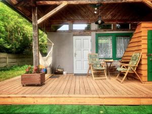 a wooden deck with chairs and a table at Leśny Zakątek agroturystyka z głaskaniem zwierząt in Ożarów