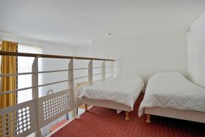 two beds in a room with a balcony at Residence Saint Goustan - maeva Home in Le Croisic
