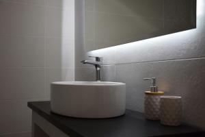 a bathroom with a white sink and a mirror at FoRest & sea view apartment in Argostoli +29 photos