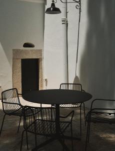 stół i krzesła w pokoju z kominkiem w obiekcie Quomorari w mieście Barletta