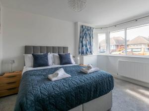 a bedroom with a large bed with towels on it at Seaside Family Bungalow for 5 people with garden and driveway parking in Kent