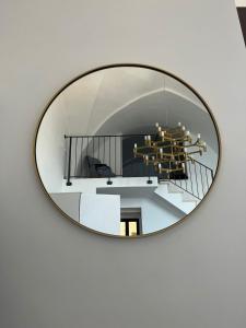 a round mirror hanging on a white wall at Dimora San Felice Il Fico in Gallipoli