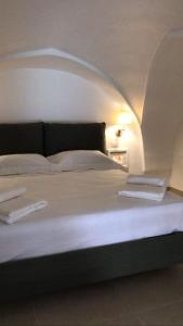 een groot wit bed met 2 handdoeken erop bij Dimora San Felice Il Fico in Gallipoli