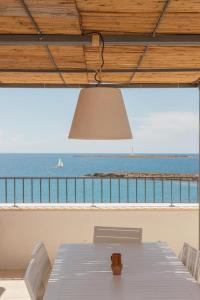 een tafel met stoelen en uitzicht op de oceaan bij Dimora San Felice Il Fico in Gallipoli