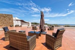 a patio with chairs and a table with an umbrella at Residence Le Vele in Stintino