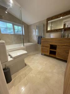 a bathroom with a tub and a sink and a mirror at The Little Lighthouse - 2 minutes from the beach in Pentewan