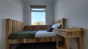 ein Holzbett in einem Zimmer mit Fenster in der Unterkunft ValleyView Cottage-Cosy, Rustic Home - Log Burner in Ushaw Moor