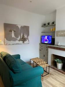 a living room with a blue couch and a tv at Casita pueblo al lado Del Mar-Vilasardemarlux4 in Vilassar de Mar