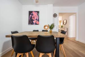 een eetkamer met een houten tafel en zwarte stoelen bij Apartamento Saint Louis I in Marbella
