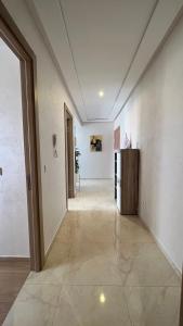 un pasillo vacío con paredes blancas y una gran puerta en Haut Standing Appartement - Centre Ville Oujda en Oujda