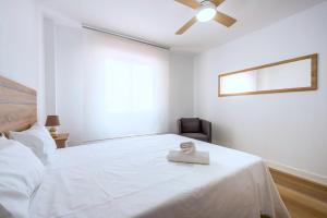 een slaapkamer met een wit bed en een plafondventilator bij Apartamento Saint Louis I in Marbella
