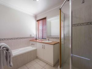a bathroom with a tub and a sink and a shower at Annand Mews Apartments in Toowoomba