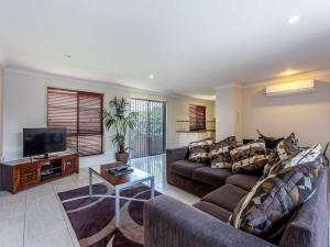 a living room with a couch and a tv at Annand Mews Apartments in Toowoomba