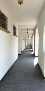 un couloir vide avec des murs blancs et du carrelage dans l'établissement Casa sul mare anni 60, à Misano Adriatico