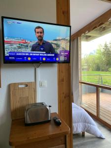 einen TV an der Wand in einem Zimmer mit einem Bett in der Unterkunft L'écrin du Bachat Chamrousse in Chamrousse