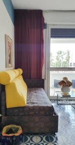- une chambre avec un lit doté d'oreillers jaunes et d'une fenêtre dans l'établissement Casa sul mare anni 60, à Misano Adriatico