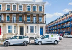 two smart cars parked in front of a building at King Palm Apartment at Sea View Terrace, Margate. in Kent