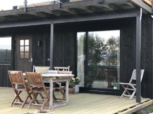 a patio with a table and chairs on a deck at Nymoen Apartment, Kvaløya in Tromsø