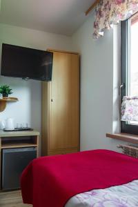 a bedroom with a bed with a red blanket at Willa OdNova in Tylicz