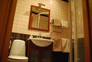 a bathroom with a sink and a toilet and a mirror at Apartment Stepana Bandery Street in Rivne