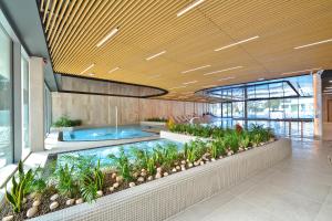 a lobby with a swimming pool and plants at Apartamenty Sea Towers SeaView by Rent like home in Międzyzdroje