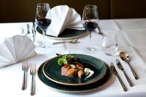 una mesa con dos platos de comida y copas de vino en Hotel zum Braunen Hirschen, en Bad Driburg