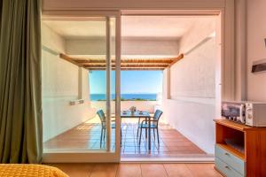 a room with a balcony with a table and chairs at Residence Le Vele in Stintino