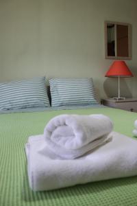 - une serviette blanche assise au-dessus du lit dans l'établissement Comfortable Apartment in the Center of Alexandroupolis, à Alexandroúpolis