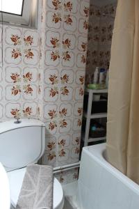 La salle de bains est pourvue de toilettes blanches et d'une baignoire. dans l'établissement Comfortable Apartment in the Center of Alexandroupolis, à Alexandroúpolis